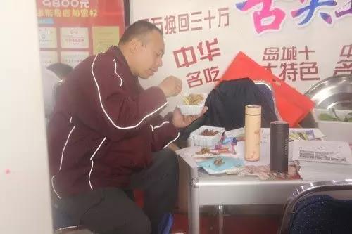 展会现场大哥用心品尝香辣鸡架饭