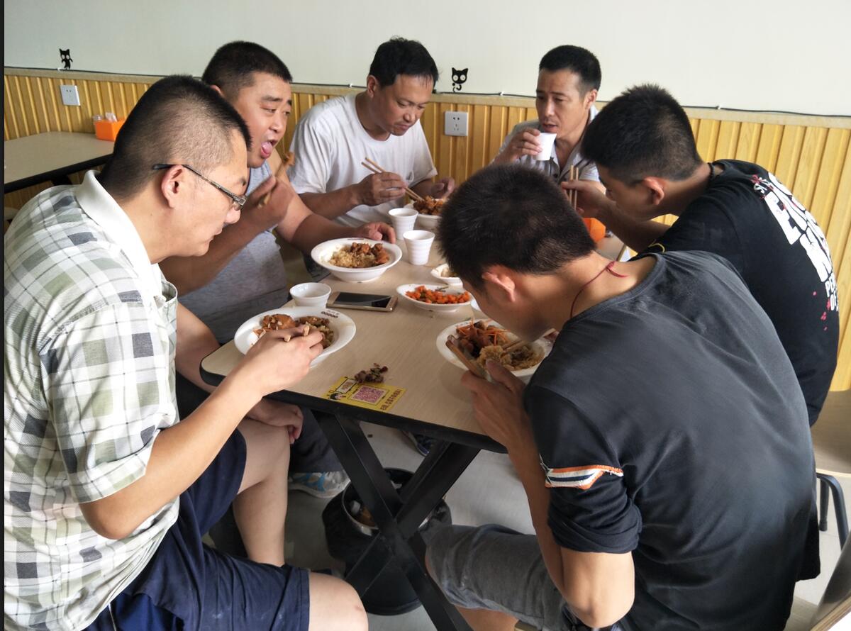一群大哥在津津有味吃香辣鸡架饭
